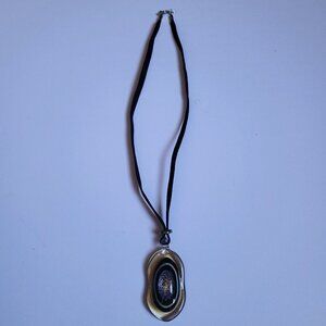 Oval-Shaped Pendant With A Black Velvet Cord.